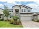Beautiful two-story home with stone accents, manicured landscaping, and a paver driveway at 7276 Notched Pine Bnd, Wesley Chapel, FL 33545