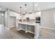 Modern kitchen boasts white cabinets, stainless appliances, central island and decorative backsplash at 7276 Notched Pine Bnd, Wesley Chapel, FL 33545