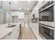 Well-lit kitchen boasting stainless steel appliances, a center island, quartz countertops, and white cabinets at 7276 Notched Pine Bnd, Wesley Chapel, FL 33545