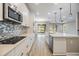 Bright kitchen featuring stainless steel appliances, white cabinets, a patterned backsplash, and an island at 7276 Notched Pine Bnd, Wesley Chapel, FL 33545