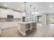 Open kitchen with white cabinets, quartz countertops, stainless steel appliances, and center island at 7276 Notched Pine Bnd, Wesley Chapel, FL 33545