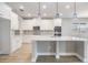 Modern kitchen with stainless appliances, white cabinets, center island, quartz counters, and pendant lighting at 7276 Notched Pine Bnd, Wesley Chapel, FL 33545