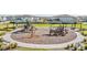 Community playground with multiple play structures, picnic shelters, and seating amidst green lawns at 7276 Notched Pine Bnd, Wesley Chapel, FL 33545