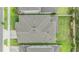 Aerial view highlighting the roof of a home, surrounded by green lawns and neighboring houses at 7276 Notched Pine Bnd, Wesley Chapel, FL 33545
