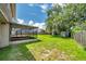 View of the spacious backyard and screened-in porch with green lawn and some storage sheds at 7309 Monterey Blvd, Tampa, FL 33625