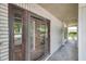 Front entryway with dark wood door, brick surround, and partial view of manicured landscaping at 7309 Monterey Blvd, Tampa, FL 33625
