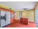 Kitchen with stainless steel refrigerator, a breakfast bar, wooden cabinets, and access to the backyard at 7309 Monterey Blvd, Tampa, FL 33625