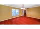 Bright living room featuring wood floors, yellow walls, large window and updated lighting fixture at 7309 Monterey Blvd, Tampa, FL 33625