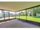 The screened-in back porch overlooks a green lawn, mature landscaping, and some storage sheds at 7309 Monterey Blvd, Tampa, FL 33625