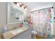 Bathroom including a shower with floral curtain, vanity and mirror at 8524 Winter Haven Dr, Hudson, FL 34667