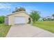Detached one-car garage with a white door and driveway leading to the home at 8524 Winter Haven Dr, Hudson, FL 34667