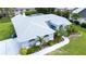 Aerial view of beautiful single-story home with blue exterior, arched windows, and manicured lawn at 8679 Burning Tree Cir, Seminole, FL 33777