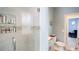 Bathroom featuring a tiled shower with glass door, single vanity and decorative accents at 8679 Burning Tree Cir, Seminole, FL 33777