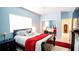 Well-lit bedroom featuring a comfortable bed, red blanket, stylish pillows, and a large window at 8679 Burning Tree Cir, Seminole, FL 33777