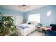 Light and airy bedroom with blue walls, white tile floors, large bed and charming decor at 8679 Burning Tree Cir, Seminole, FL 33777