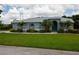 Well-maintained home boasts a lush lawn, elegant landscaping, and a serene ambiance, creating an inviting curb appeal at 8679 Burning Tree Cir, Seminole, FL 33777