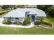 Beautiful single-story home with blue exterior, arched windows, manicured lawn and palm trees at 8679 Burning Tree Cir, Seminole, FL 33777