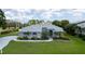 Beautiful single-story home with blue exterior, arched windows, manicured lawn and palm trees at 8679 Burning Tree Cir, Seminole, FL 33777