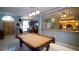 Open concept with a game room featuring a pool table and bar, leading to the kitchen at 8679 Burning Tree Cir, Seminole, FL 33777