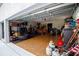 Open garage reveals ample space with workout gear and other items, useful for storage or hobbies at 8679 Burning Tree Cir, Seminole, FL 33777