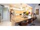 Well-equipped kitchen with a stainless steel refrigerator, granite countertop island, and bar stool seating at 8679 Burning Tree Cir, Seminole, FL 33777