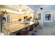 Well-equipped kitchen with a stainless steel refrigerator, granite countertop island, and bar stool seating at 8679 Burning Tree Cir, Seminole, FL 33777