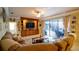 Comfortable living room boasts a large sectional sofa, custom built-ins, and a sliding door to the patio at 8679 Burning Tree Cir, Seminole, FL 33777