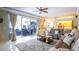 Spacious living room with a plush sofa, a large window view of the patio, and decorative ceiling fan at 8679 Burning Tree Cir, Seminole, FL 33777