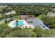 Aerial view of the community pool, clubhouse, and tennis court, surrounded by lush greenery and landscaping at 9008 Egret Cove Cir, Riverview, FL 33578