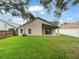 View of the backyard with a grassy lawn, slider, and a covered patio at 9008 Egret Cove Cir, Riverview, FL 33578