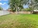 Large grassy backyard featuring a wood fence and mature trees at 9008 Egret Cove Cir, Riverview, FL 33578