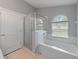 A bathroom with a tub, shower, and arched window offers a bright and functional space at 9008 Egret Cove Cir, Riverview, FL 33578