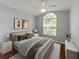 A bedroom with wood floors, a large window, and neutral decor creates a calming space at 9008 Egret Cove Cir, Riverview, FL 33578