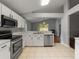 Modern kitchen with white cabinets, stainless steel appliances, and an open layout with tile flooring at 9008 Egret Cove Cir, Riverview, FL 33578