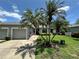 Charming home exterior featuring a garage, tropical landscaping, and a brick walkway at 907 San Carlos Ne Ave, St Petersburg, FL 33702