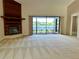 Spacious living room featuring a brick fireplace and sliding glass doors with a view of the lake at 907 San Carlos Ne Ave, St Petersburg, FL 33702