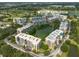 Aerial view showcases condo community nestled around a central pond, complemented by mature trees at 960 Starkey Rd # 2103, Largo, FL 33771