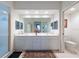 Bright bathroom featuring a double vanity with white cabinets, a large mirror and a walk-in shower at 960 Starkey Rd # 2103, Largo, FL 33771
