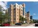 Multi-story condo building featuring a mix of tan and blue paint, multiple windows, and lush surrounding foliage at 960 Starkey Rd # 2103, Largo, FL 33771