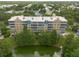 Rear view of well-maintained condo building with pond views, multiple balconies and lush landscaping at 960 Starkey Rd # 2103, Largo, FL 33771