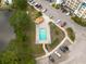 Aerial view of outdoor pool, lounge chairs, landscaping, covered picnic area, and ample parking at 960 Starkey Rd # 2103, Largo, FL 33771