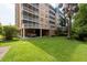 Exterior view of building with green lawn, mature trees, and covered parking, creating a desirable living environment at 960 Starkey Rd # 2103, Largo, FL 33771