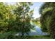 Picturesque view from the balcony, featuring a peaceful lake surrounded by trees and lush greenery at 960 Starkey Rd # 2103, Largo, FL 33771