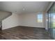 Open-concept living room with light gray walls, wood flooring and sliding glass doors at 9921 Surrey Rose Dr, San Antonio, FL 33576