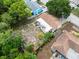 Aerial view of the property showing backyard, nearby houses, and mature trees surrounding the lot at 9927 Woodridge Ct, Port Richey, FL 34668