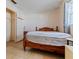 Bright bedroom features a wooden bed frame, window, closet, and tile flooring at 9927 Woodridge Ct, Port Richey, FL 34668