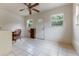 Bright sun room with white tile floors, ceiling fan, windows, and door to outdoors at 9927 Woodridge Ct, Port Richey, FL 34668