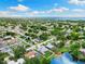 Expansive aerial view of a home with a private pool and lake access in a lush, green neighborhood with distant ocean views at 996 56Th S Ave, St Petersburg, FL 33705