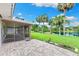 Relaxing patio with a screened-in porch overlooking the backyard, lake and mature palm trees at 996 56Th S Ave, St Petersburg, FL 33705