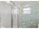 Bathroom featuring a tiled shower with a glass enclosure and floral wallpaper accenting the wall at 996 56Th S Ave, St Petersburg, FL 33705